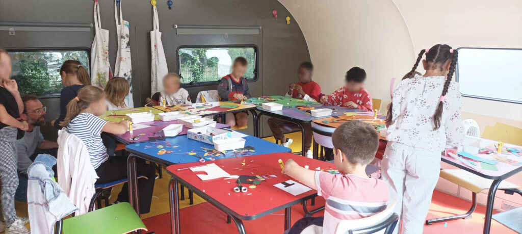 groupe d'enfants qui font des ateliers artistiques dans une grande cabane - caravane